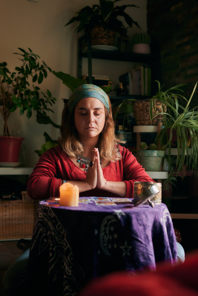 Pythoness woman meditates with tarot cards on a table