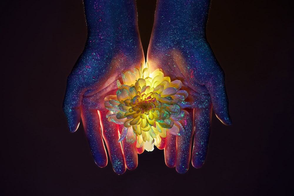 Overhead shot of a glowing crystal ball and hands surrounded by smoke and cards.